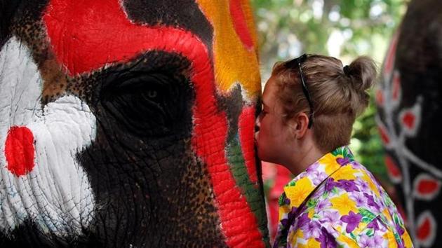 A volunteer kisses an elephant in celebration during the Songkran water festival. (Chaiwat Subprasom / Reuters)