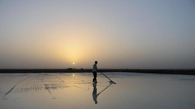 A salt pan worker of the Agariya community in Gujarat works in the remote and arid Little Rann of Kutch, Gujarat. Children of these workers accompany their parents for nearly eight months of the year during the salt farming season. Sheltered beneath a canvas sheet to escape the blistering desert sun, miles from any roads or power lines, a group of children huddle around a digital tablet and experience the internet for the very first time through a remote wi-fi connection powered by a van bringing the digital world to them. (AFP)