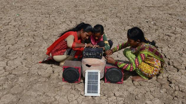 Puja Ganeshbhai Muladiya (R) along with her sisters prepare for a traditional Garba (Gujarat's folk dance) as they connect a solar panel-powered music systems in the Little Rann of Kutch. (AFP)
