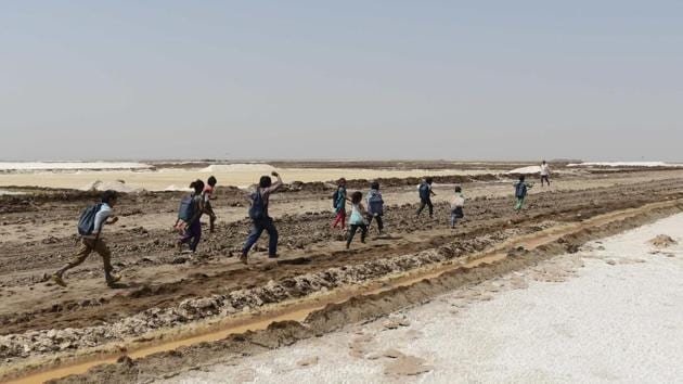 A group of children run as they finish a tent school workshop with the 'Zero Connect' programme, in the Little Rann of Kutch. They are part of some 10,000 families living on the inhospitable salt flats of western Gujarat, where their parents work eight months a year in extreme conditions. (AFP)