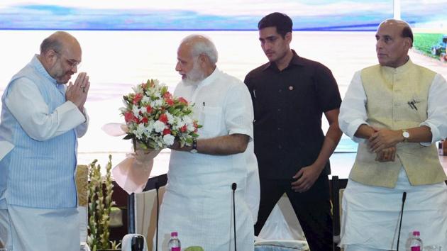 PM Narendra Modi is greeted by BJP president Amit Shah and home minister Rajnath Singh in New Delhi on Monday.(PTI Photo)