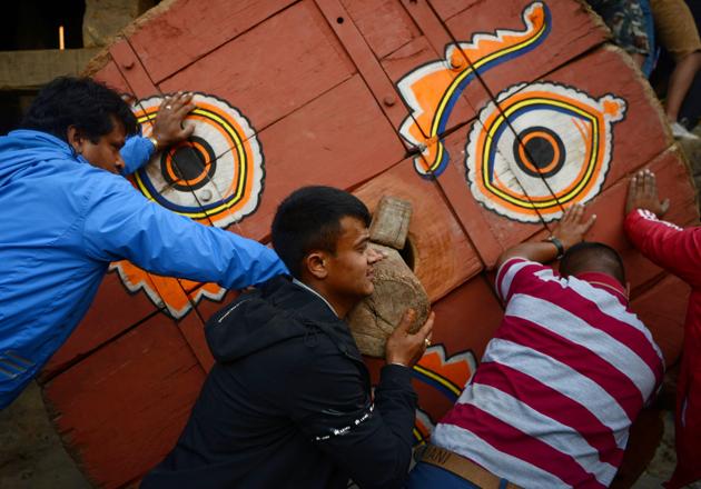 Nepalese Hindu devotees push a wooden chariot through the crowd during the festival. (Prakash Mathema/AFP)
