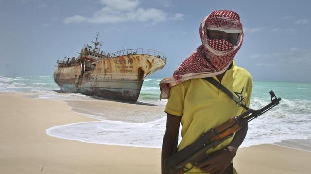 In this file photo, a masked Somali pirate stands near a Taiwanese fishing vessel that washed up on shore after the pirates were paid a ransom and released the crew, in the once-bustling pirate den of Hobyo, Somalia.(AP)