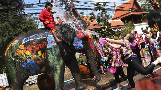 Tourists splash water on an elephant. This cleansing ritual is to bring luck and prosperity for the coming year. (AP)