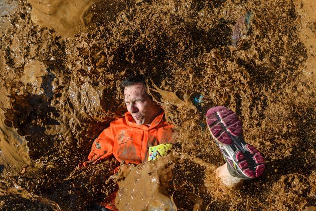 A competitor lands in mud as they take part in the ‘Barjot Run’ obstacle race in Biere, western Switzerland. (Fabrice Coffrini/ AFP)