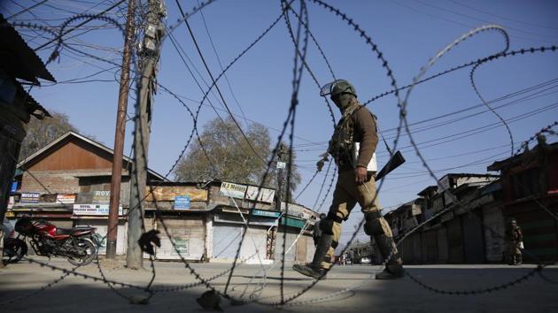 A paramilitary soldier guards a check point during a strike in Srinagar on Monday. Three videos showing soldiers being assaulted and abused by mobs shouting “India go back” have gone viral.(AP)