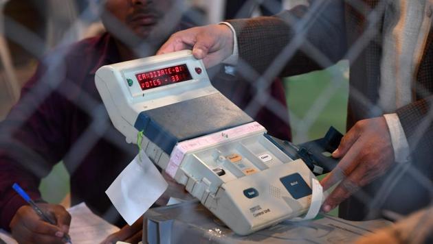 An election official shows an open Electronic Voting Machine (EVM) to political agents at a counting centre in Ghaziabad on March 11.(AFP Photo)