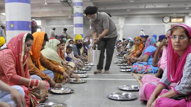 A devotee serving langar (community kitchen) on the occasion of Baisakhi festival at Dukhniwaran Sahib gurdwara in Ludhiana. (Gurminder Singh/HT Photo)