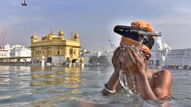 Devotee take a holy dip in the sarover (water tank) at the Golden Temple in Amritsar  to mark Baisakhi festival. (Gurpreet Singh/ HT Photo) 
