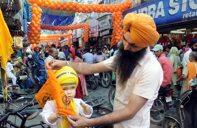 A shopkeeper decorating a dummy in traditional Sikh attire outside his shop in Patiala on Thursday. (Bharat Bhushan/HT)