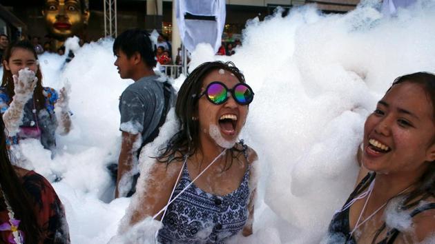 Revellers react at a foam party during Songkran Festival celebrations in Bangkok. Major streets are closed to traffic as they become the center for such foam and water fight parties. (REUTERS)