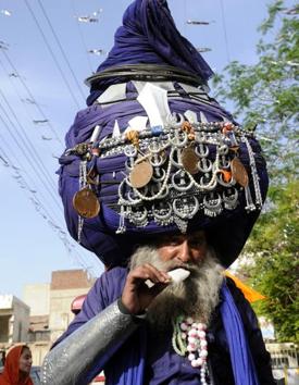 Nihang Sikh Balwant Singh, famous for wearing an 800-metre turban, enjoying ice cream during a nagar kirtan (procession) on the occasion of Baisakhi in Patiala on Thursday. (Bharat Bhushan/HT)