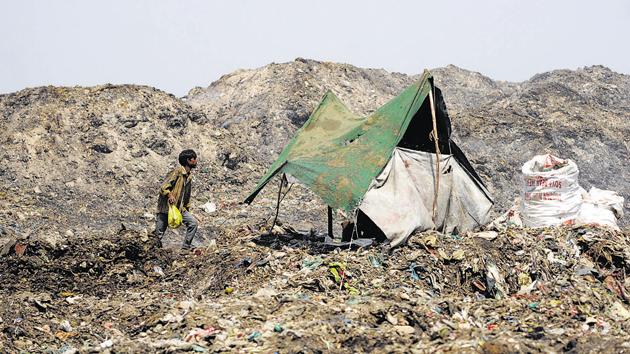 A man approaches his makeshit house on the garbage dumping ground in Ghaila village on Hardoi Road, which is almost 20km away from Lucknow.(Deepak Gupta/ HT Photo)