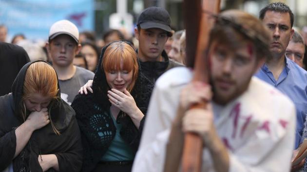 Kristy Morgan, third left, plays Mary Magdalene and Brendan Paul, second right, plays the part of Jesus as parishioners from the Wesley Mission re-enact journey of the cross procession on Good Friday in Sydney. (Rick Mycroft/AP)