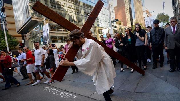 25-year-old student Brendan Paul depicting himself as Jesus Christ carries a cross in a re-enactment from the bible, on Good Friday in Sydney. They normally fast on this day unless they have health issues or are below the prescribed age. (Peter Parks/AFP)
