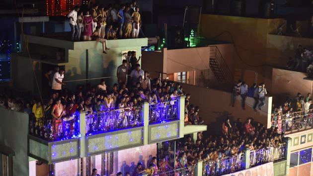 People watching the festival proceedings from neighbourhood roof tops on the occasion of Karaga. (Arijit Sen/HT Photo) People watching the festival proceedings from neighbourhood roof tops on the occasion of Karaga. (Arijit Sen/HT Photo)