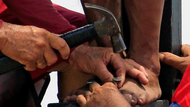 A penitent’s feet is being nailed on a wooden cross during a Good Friday crucifixion re-enactment in Cutud village, Pampanga province, north of Manila, Philippines. Good Friday is observed as a public holiday in various countries such as India, Canada, the UK, Germany, Australia, Bermuda, Brazil, Finland, Malta, Mexico, New Zealand, Singapore and Sweden among others. (Romeo Ranoco/REUTERS)