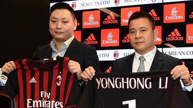 Yonghong Li (R), new owner of the AC Milan football club, poses with Rossoneri Sport Investment Lux representative David Han Li.(AFP)