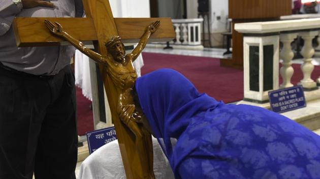 A lady kisses the Holy Cross during the Good Friday mass gathering at Sacred Heart Cathedral in New Delhi. (Saumya Khandelwal/HT PHOTO)