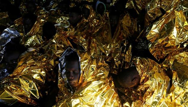 Migrants rest on the deck of the Malta-based NGO Migrant Offshore Aid Station (MOAS) ship Phoenix after being rescued. (Darrin Zammit Lupi / Reuters) Migrants rest on the deck of the Malta-based NGO Migrant Offshore Aid Station (MOAS) ship Phoenix after being rescued. (Darrin Zammit Lupi / Reuters)