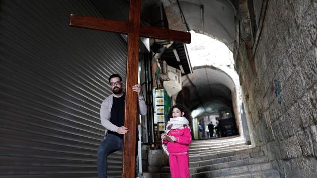A Christian pilgrim and a child carry a wooden cross along the Via Dolorosa (Way of Suffering) in Jerusalem’s Old City. Churches observe the day with a service that normally takes place in the evening, where they remember Christ’s death with hymns, thanksgiving prayers, talk about the special significance that the day holds and observe the Lord’s Supper. (Thomas Coex/AFP)