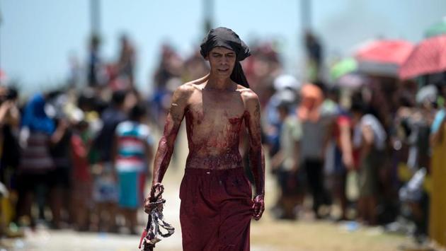 A flagellant walks in front of crosses before a re-enactment of the Crucifixion of Christ. Catholics do not eat meat on Good Friday but can eat fish instead and it is also customary to eat warm hot cross buns. (Noel Celis/AFP)