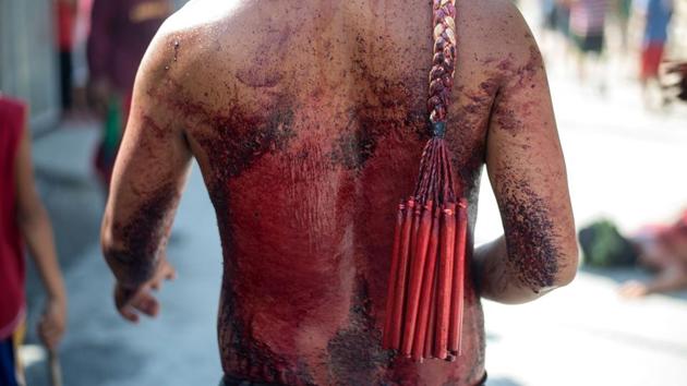 Participants whip their bloodied backs with bamboo as part of their penitence during the re-enactment of the crucifixion of Jesus Christ. Jesus washed the feet of his disciples just before the Last Supper took place. This practice is repeated on the Thursday before Good Friday, by the pope who washes the feet of up to 12 communicants. (Noel Celis/AFP)