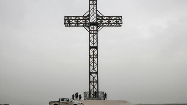 People stand by a big cross in the town of Qaraqosh. In the desecrated churches of Qaraqosh, Christians are busy removing graffiti daubed by the Sunni Muslim militants during two and a half years of control - only for new slogans to have appeared, scrawled by Shi’ite members of the Iraqi forces fighting street to street with the jihadists in Mosul. (Marko Djurica/Reuters)