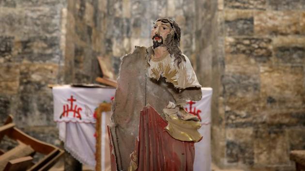 A damaged statue of Jesus Christ is seen inside a church. Germany alone took in 130,000 Iraqis, among them many Christians, in 2015 and 2016. But, most ended up in Erbil with relatives or in homes paid for by aid agencies. (Marko Djurica/Reuters)