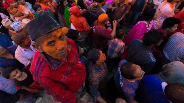 Nepalese people seen in red and orange as vermillion powder was thrown in all directions for the Sindoor Jatra festival which is part of the week-long Bisket Jatra festival. (Photo By Nipun Prabhakar)