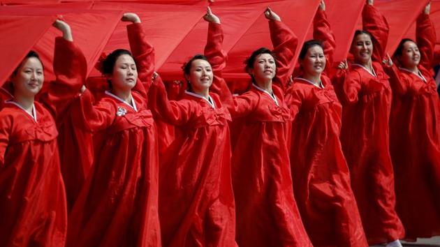 Attendees carry sheets in the colours of North Korea's national flag during a military parade. (Damir Sagolj / REUTERS)