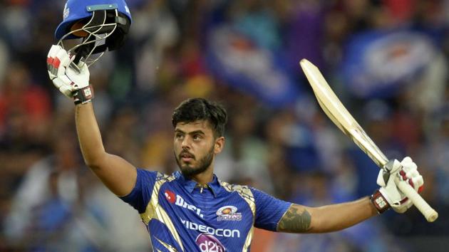 Mumbai Indians cricketer Nitish Rana raises his bat and helmet after scoring his half century. (AFP)