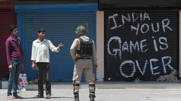 A paramilitary soldier stops passersby in downtown Srinagar.(Waseem Andrabi/ HT File)