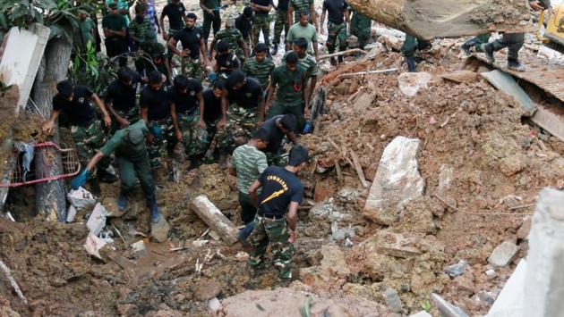 Emergency workers looking for survivors after a massive rubbish dump collapsed in Sri Lanka . (Dinuka Liyanawatte / REUTERS)