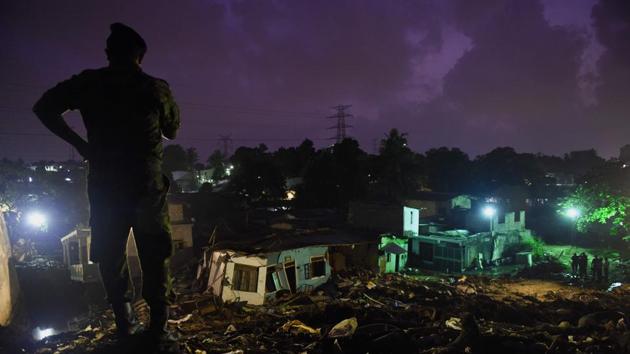 A Sri Lankan military official stands overlooking damaged homes at the site of a collapsed garbage dump in Colombo. (ISHARA S. KODIKARA / AFP)
