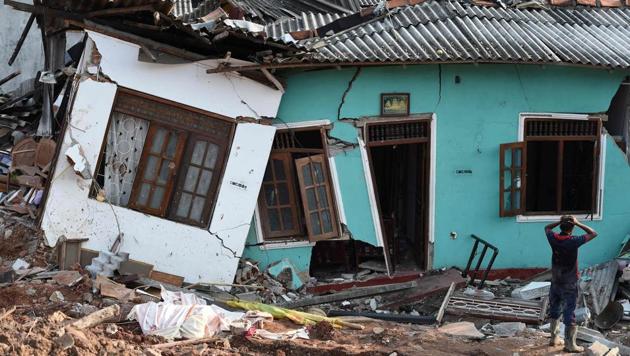 A Sri Lankan resident walks through damaged homes at the site of a collapsed garbage dump in Colombo on April 16, 2017. (ISHARA S. KODIKARA / AFP)