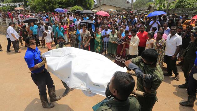 Sri Lankan government soldiers and rescue workers cary a body recovered from the site of a garbage dump collapse. (Eranga Jayawardena / AP)