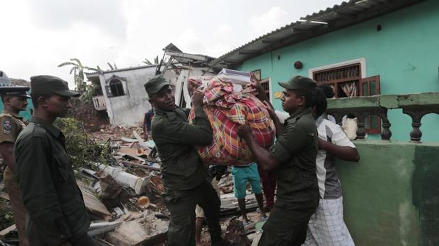 Sri Lankan army soldiers and rescue workers salvage belongings after houses are buried in a collapse of a garbage dump . (Eranga Jayawardena / AP)
