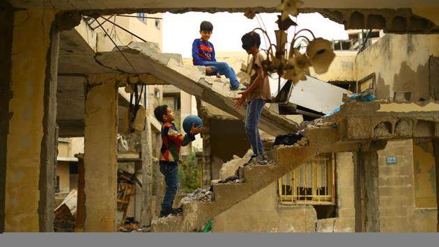 Palestinian children play amidst the ruins of a building destroyed during the 50-day war between Israel and Hamas militants during the summer of 2014 in Gaza City, on April 13, 2017. (MOHAMMED ABED /AFP)