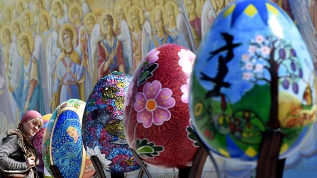 A woman looks at huge Easter eggs as they walk in the open air festival in the center of Kiev on April 12, 2017. Some 500 traditional Ukrainian pysankas, painted Easter eggs, are presented in the center of Kiev before the celebration of the Easter, main holiday of the Orthodox church, on April 16. (Sergei SUPINSKY / AFP)
