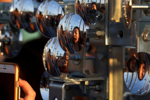People are reflected in a parabolic mirror during the Festival. (Carlo Allegri / REUTERS)