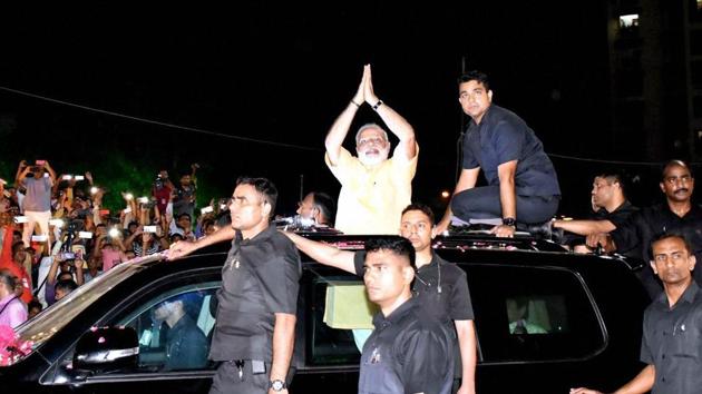 Prime Minister Narendra Modi gestures to supporters during a road show in Surat on Sunday.(PTI)