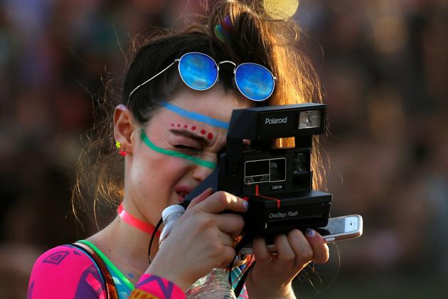 A woman takes a photo with a Polaroid camera. (Carlo Allegri / REUTERS)