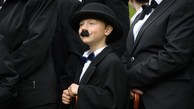 A child dressed as 'The Tramp' poses with other people for a photograph. (Richard Juilliart / AFP)