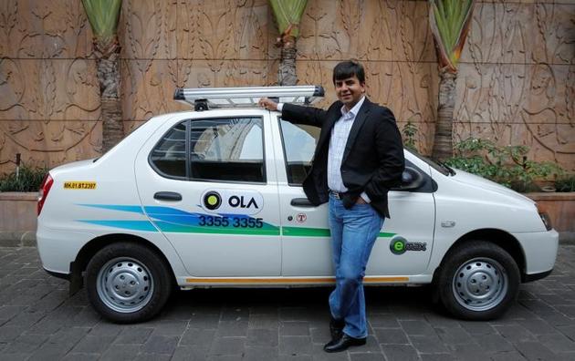 Bhavish Aggarwal, CEO and co-founder of Ola, an app-based cab service provider, poses in front of an Ola cab in Mumbai.(Reuters)