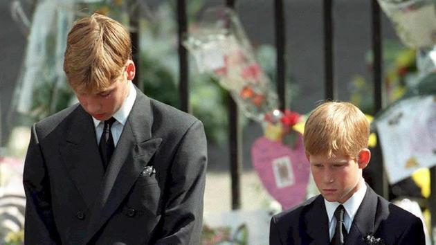 Photo taken on September 06, 1997 shows Britain's Prince William (L) and Prince Harry (R) bowing their heads as their mother Prince Diana's coffin is taken out of Westminster Abbey following her funeral service.(AFP File Photo)