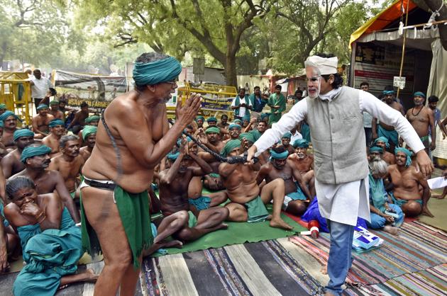 A man wearing PM Narendra Modi’s mask beats a Tamil Nadu farmer during a play as part of protest seeking compensation for drought in the state, at Jantar Mantar in New Delhi on April 18. (Mohd Zakir/HT Photo) A man wearing PM Narendra Modi’s mask beats a Tamil Nadu farmer during a play as part of protest seeking compensation for drought in the state, at Jantar Mantar in New Delhi on April 18. (Mohd Zakir/HT Photo)