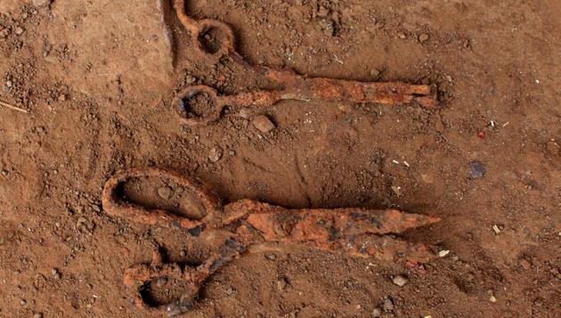 Scissors found at an exhumation site are photographed in the village. (Jose Cabezas / Reuters)