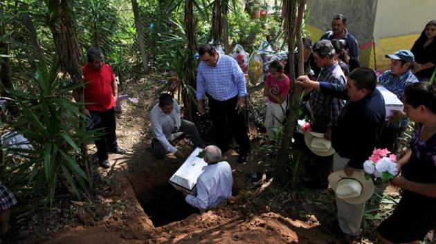 Relatives participate in the funeral of Petrona Chavarria and Vilma Ramos, who died in the El Mozote massacre. In 1991, Argentine forensic experts began helping to disinter remains to identify the victims (Jose Cabezas / Reuters)