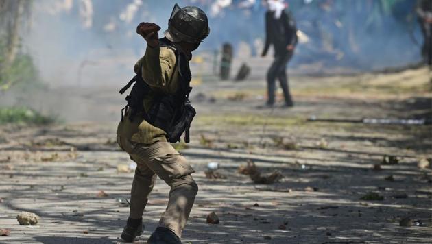 A security personnel throws a stone towards protesters during clashes near a college in central Srinagar's Lal Chowk.(AFP File Photo)